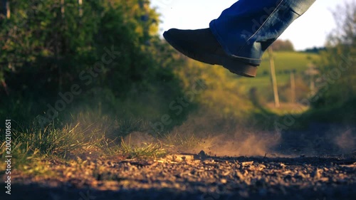 Feet kicking up dust on road