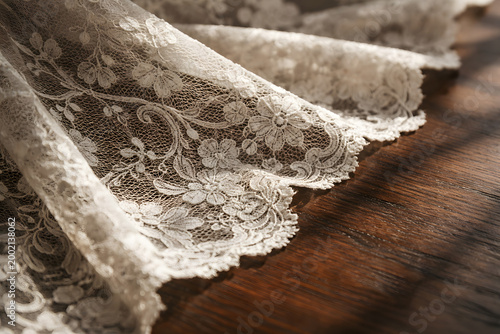 Intricate vintage lace fabric resting on dark wood