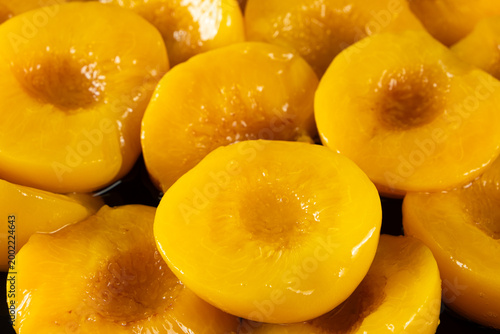 Obraz na plátně Sweet canned peach halves in sugar syrup close up