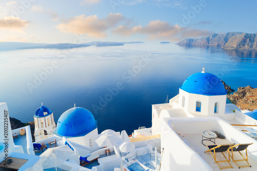 Fotografie white church belfry, brigh blue domes and volcano caldera with sea landscape, be