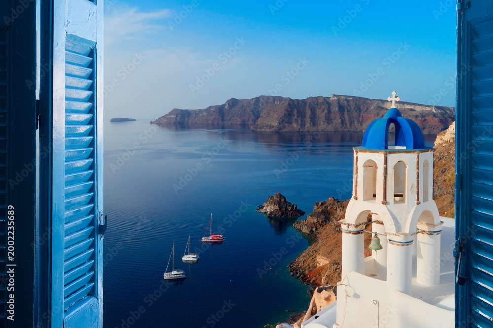 Obraz premium white church belfry with blue dome and volcano caldera with sea landscape, beautiful details of Santorini island, Greece