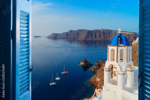 white church belfry with blue dome and volcano caldera with sea landscape, beautiful details of Santorini island, Greece