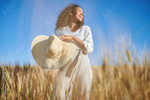 Young woman enjoying summer day in wheat field