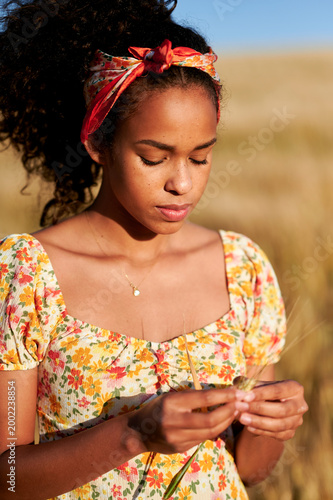 Young woman enjoying summer day in wheat field