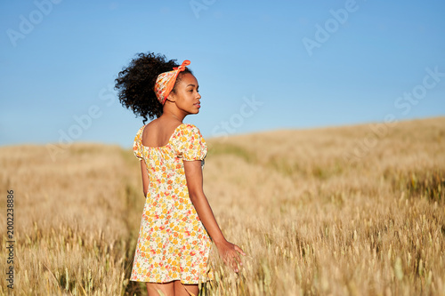 Young woman enjoying summer day in wheat field