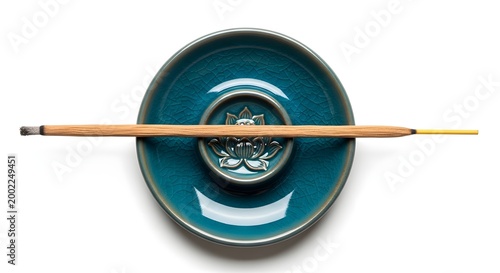 Burning incense stick resting on a decorative lotus-shaped ceramic holder against a white background