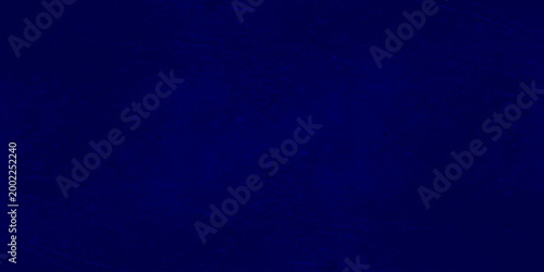 Dark blue grunge texture background with vignetting, abstract navy blue mottled wall surface