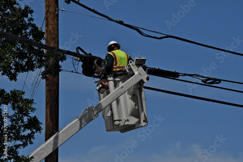 Linesman working on fiber optic lines using cherry picker 