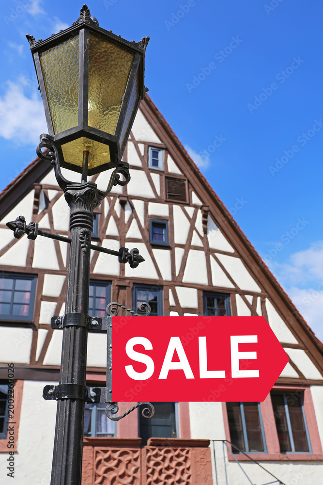 Obraz premium Sign for sale outside a building in a town with a clear blue sky