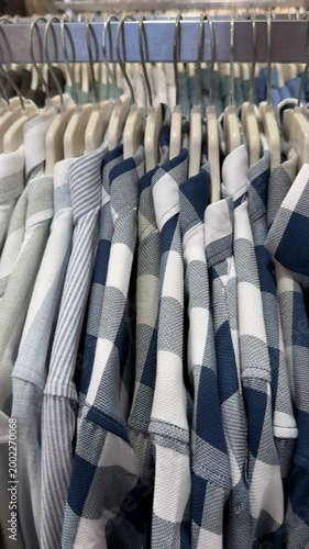 Shirts on hangers in clothing store display background showcasing various striped patterns
