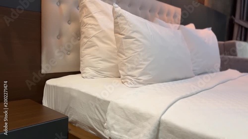 Hotel bedroom interior with white bed linens and tufted headboard, suitable as background