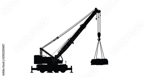 Black silhouette of a mobile crane lifting a heavy load with its long boom and pulley system