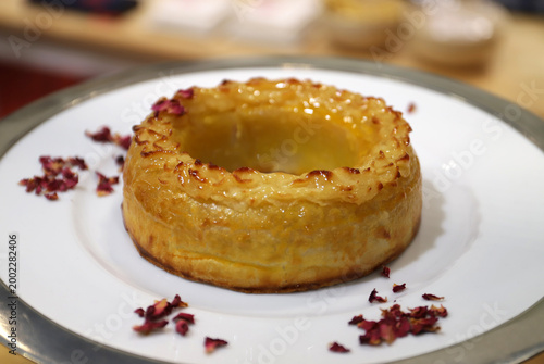 pastel gourmet horneado en forma de rosca, de hojaldre, yema de huevo y cabello de ángel