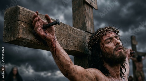 Jesus Christ crucified on wooden cross with crown of thorns and bloody hand. Man suffering during crucifixion under dramatic dark stormy sky. Religious scene for Easter, faith, salvation.