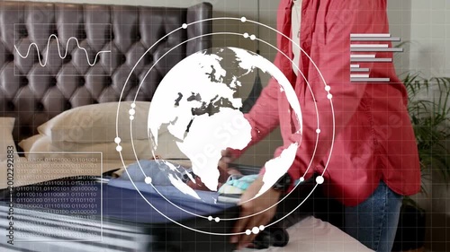 Couple packing luggage, travel plans causing folding, handing hat, phone, HUD globe overlaying