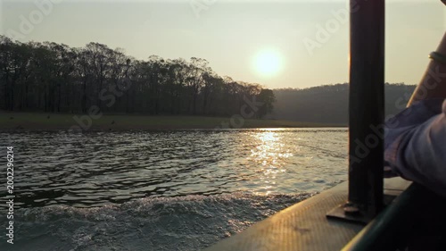 Sunset boat ride along the river in the forest at dusk with reflections on the water and silhouettes of trees