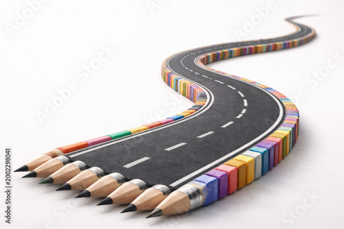 A winding road of colored pencils on a light background. Space for text.