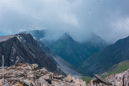 Фотография Rocky peaked mountain top of triangle shape in low rainy cloud
