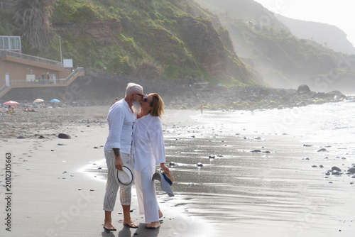 Quadro em tela lifestyle with caucasian senior couple resting on beach, holding hands, happy in
