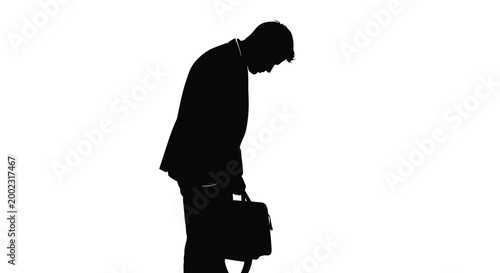 Silhouette of a man with a briefcase looking down sadly