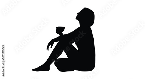 Silhouette of a woman sitting on the floor with a cup in her hand relaxed