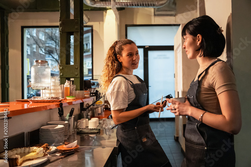 Barista coworker talk in cafe kitchen during shift