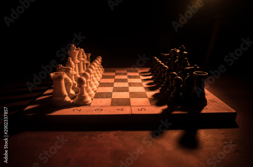 Chess board game concept of business ideas and competition. Chess figures on a dark background with smoke and fog.