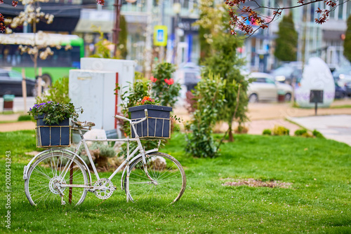 Vintage bicycle planter in urban park with lush greenery and flowers