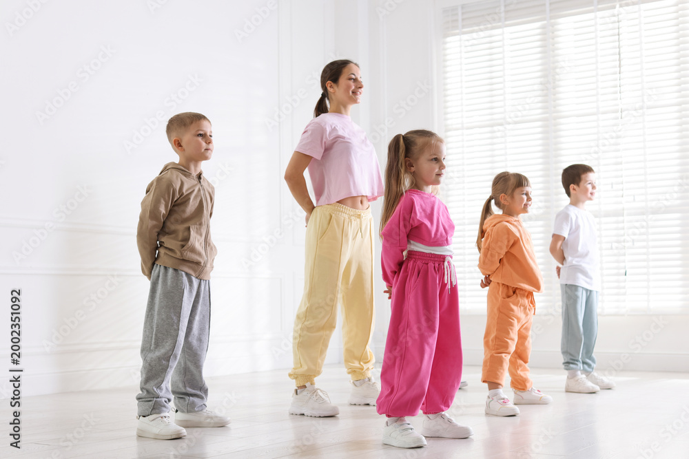 Fototapeta premium Professional dance teacher training children in studio