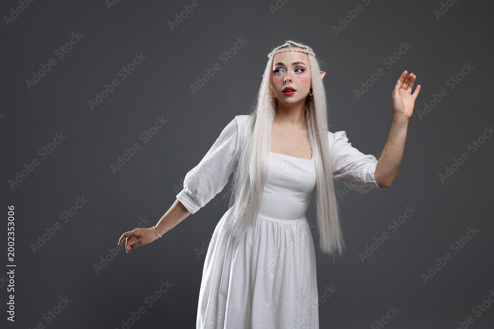 Fototapeta premium Beautiful girl dressed as elf on grey background