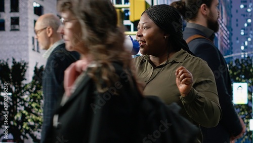 Εκτύπωση καμβά African american female adult promoting something on megaphone in city center, advertisement and street marketing for diverse group of people passing by