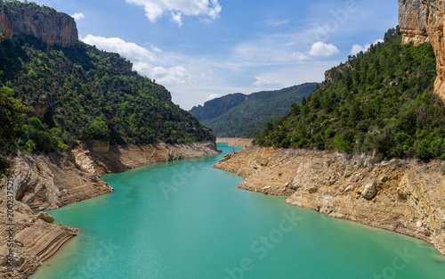 Turquoise reservoir water in scenic mountain canyon with rocky cliffs