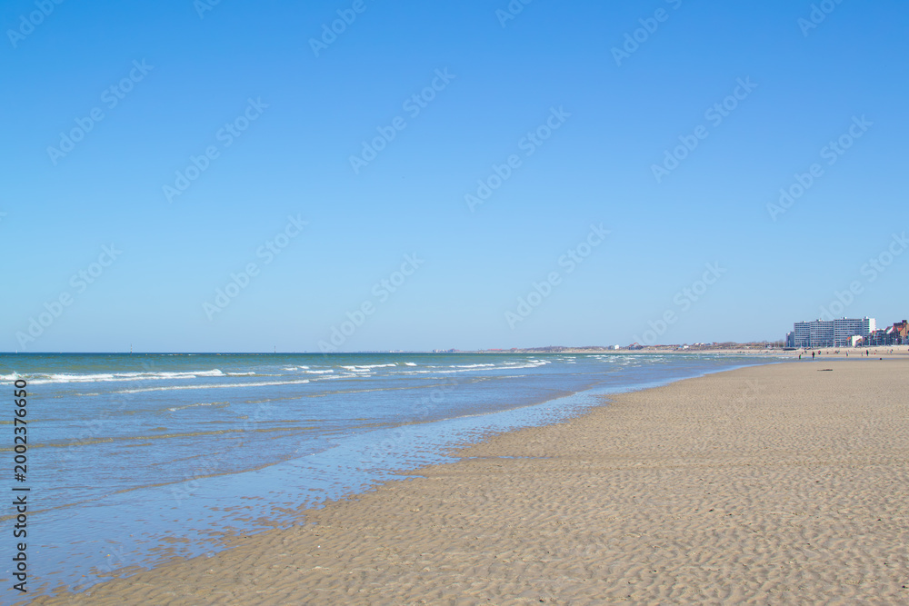 Fototapeta premium Dunkirk beach, Plage Dunkerque, promenade near the sea, coastline, sand, dunes, Malo-les-Bains, France, La Manche, people walking far away, a large beach known from the Second World War