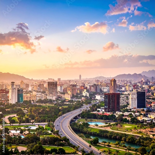 Urban cityscape with highway and mountains at sunset