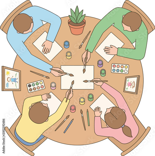 Students gather around a circular wooden table to practice painting with watercolors and brushes in a classroom setting.