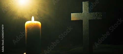 Religious cross and a burning candle glowing in a dark, spiritual setting with golden light rays.