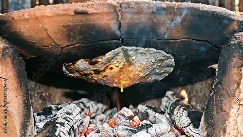 Traditional clay oven baking over embers.