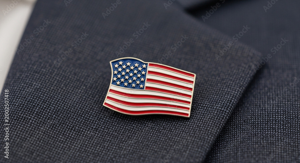 Obraz premium American Flag Lapel Pin on a Textured Dark Suit Jacket, Symbolizing Patriotism and National Pride