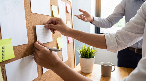 Obraz na płótnie Creative business professionals brainstorming ideas on a cork board, planning strategy with team collaboration