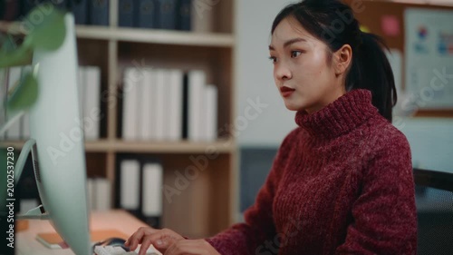 Asian businesswoman working on a desktop computer. Focused professional using technology for communication and project management in office