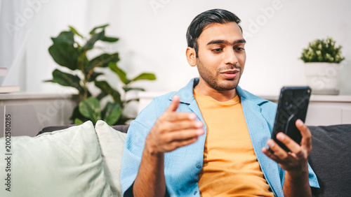 Fotografie Indian man using smartphone video calling speech convince for business communica