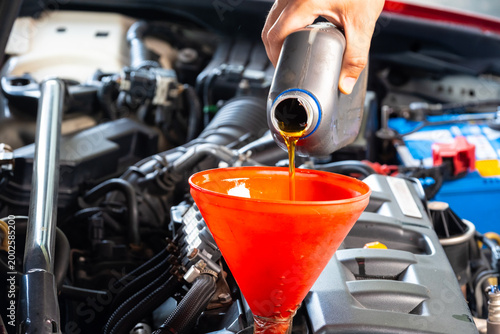 Refueling and pouring oil quality into the engine motor car Transmission and Maintenance Gear .Energy fuel concept.	