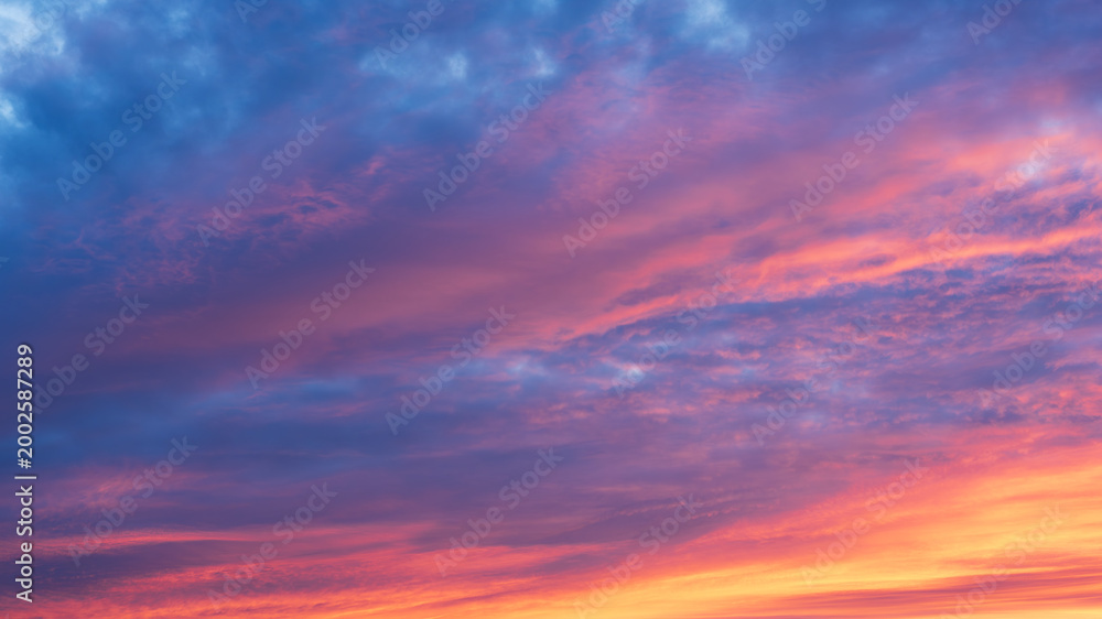 Fototapeta premium Vibrant colorful sunset sky with dramatic clouds and soft gradient tones