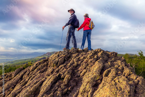 happy mature married couple traveling through the Ural mountains on a summer day