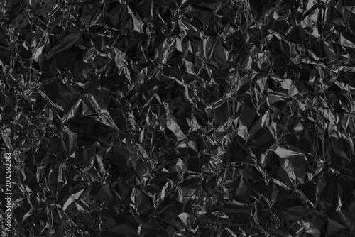 Shiny black grey foil metal texture, abstract wrapping paper for background and design art work.