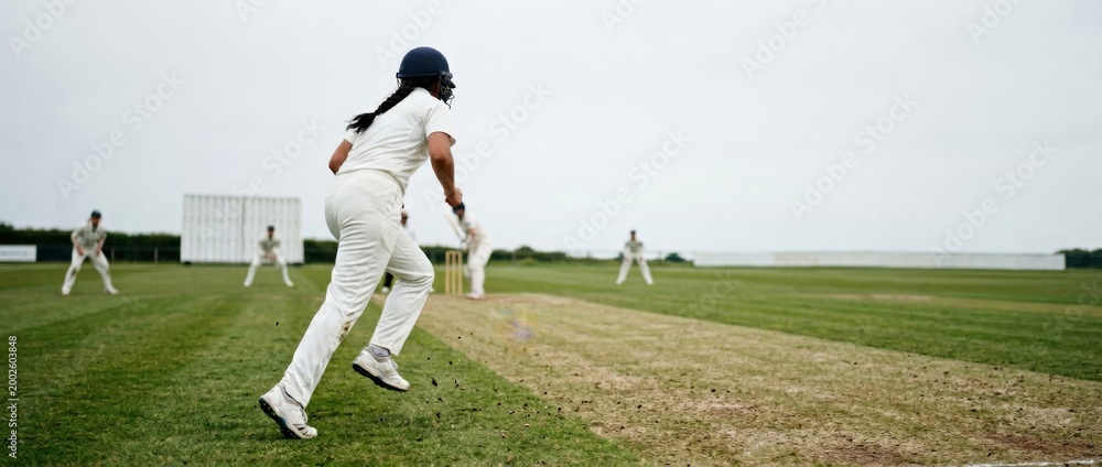 Obraz premium Female Cricketer Running on Pitch During a Match.