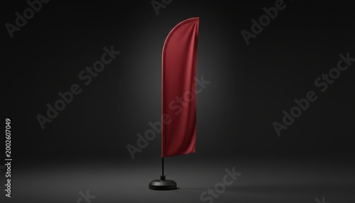Tall cherry red feather flag standing on a base against a dark background for outdoor event marketing, retail promotion mockup and brand advertising display
