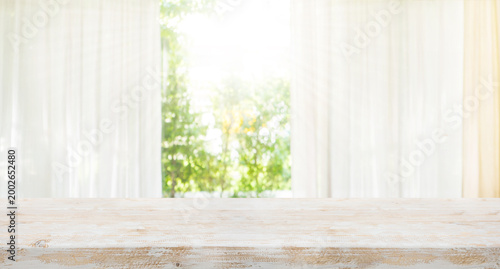 Rustic Living style with white wood table top on blur of curtain window and abstract green from garden with sunlight.Background design