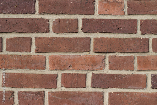Foto Red brick wall with mortar joints, showcasing a textured surface and varying sha