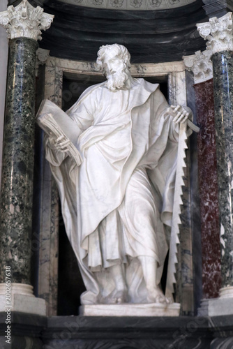 Statua in marmo bianco di San Simone Apostolo con la sega del martirio inserita in una nicchia barocca monumentale affiancata da grandi colonne in marmo verde in San Giovanni in Laterano a Roma.